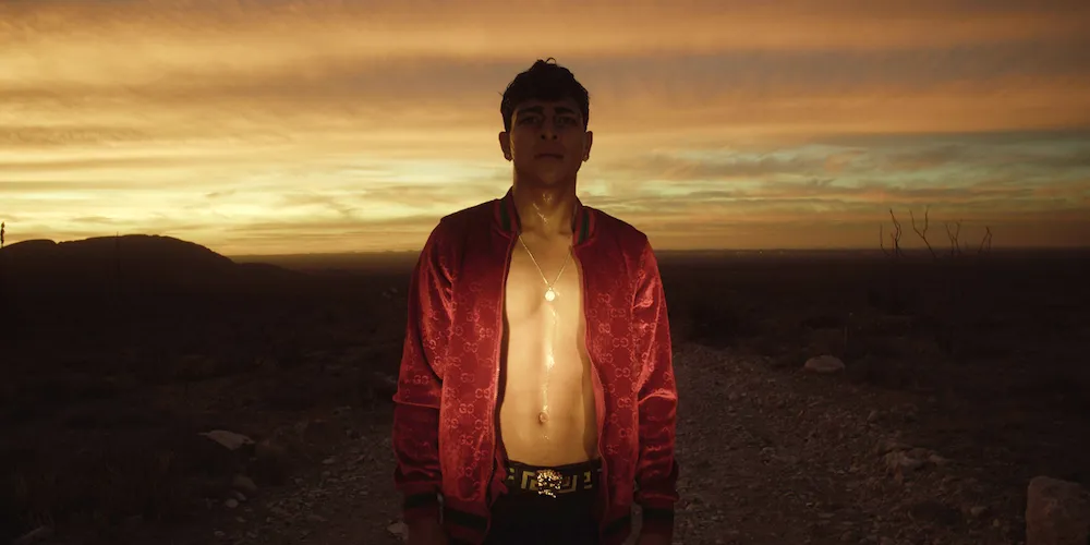 A man stands outside at sunset looking into the camera