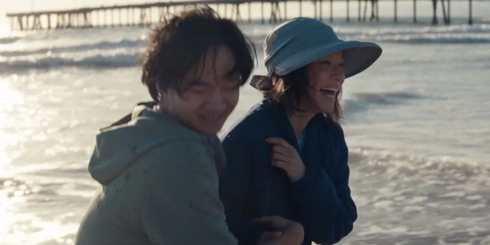 a man and woman laugh on the beach