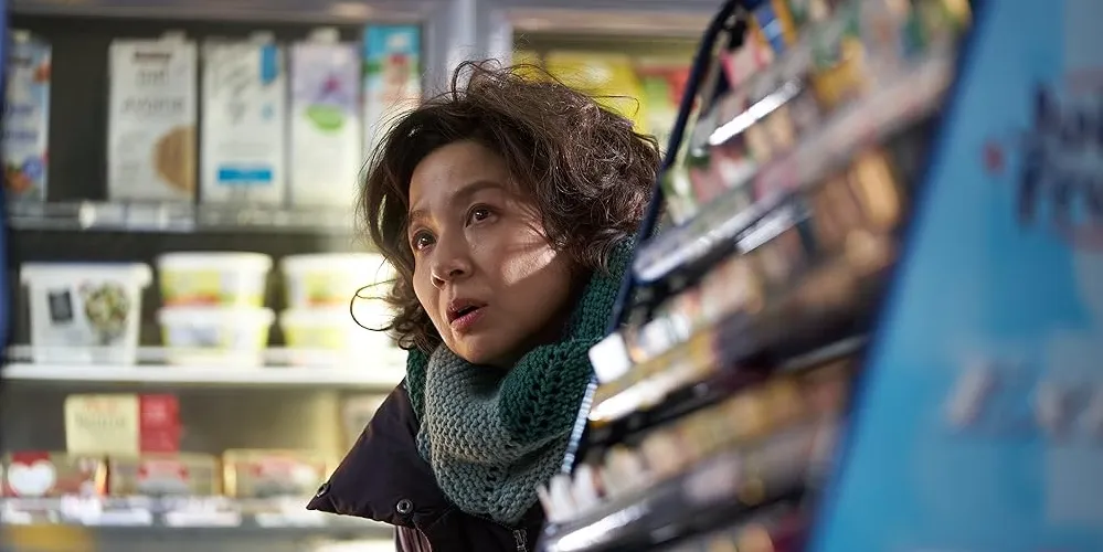 Woman peering from behind a grocery isle. 