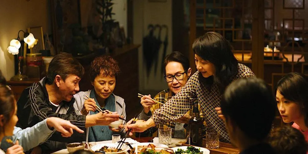 A group of people sit around a table, eating. 