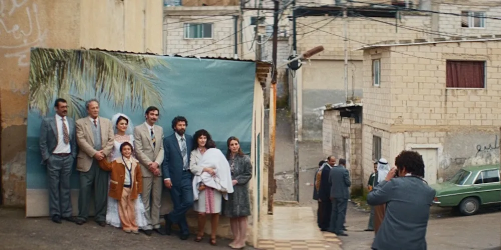 a family poses for a portrait outside in front of a backdrop