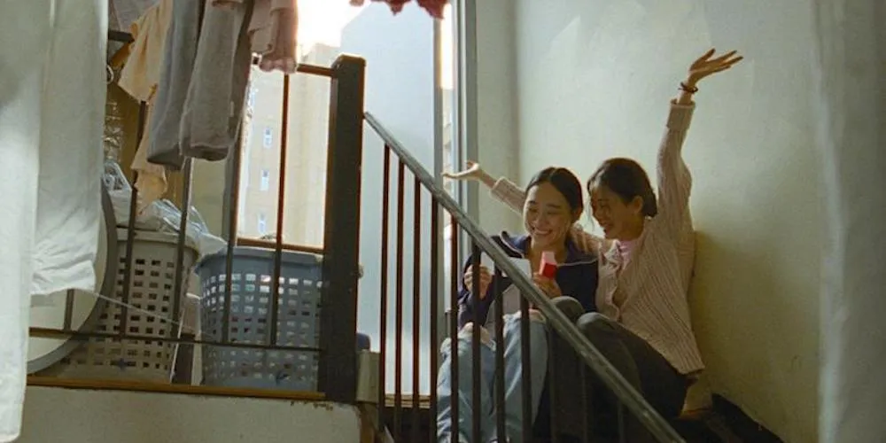 Two woman sit on stairs. 