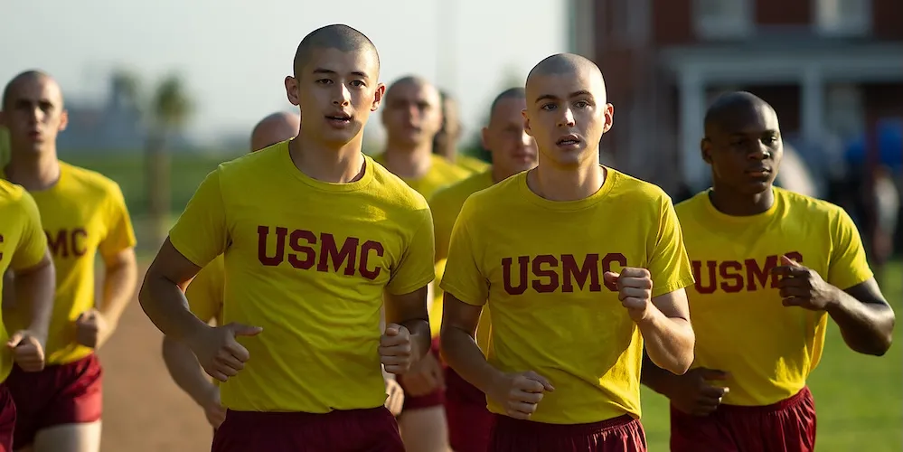 a group of men in uniform jog side-by-side outside