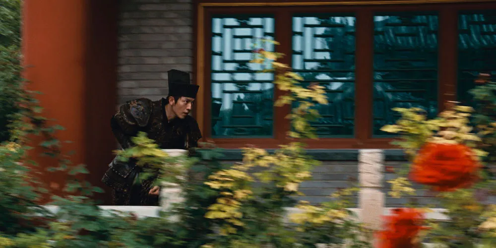 a man in a historical costume runs past a building