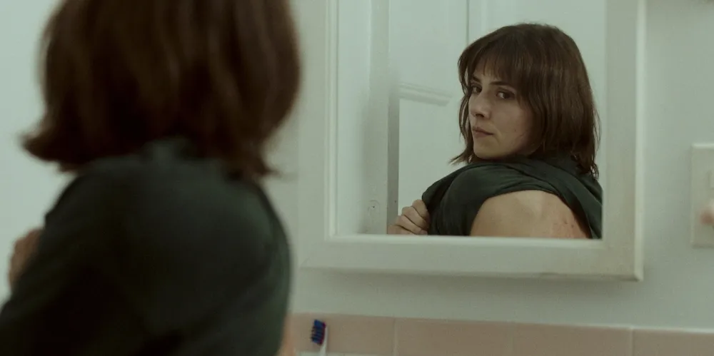 Woman looks at reflection in a mirror.
