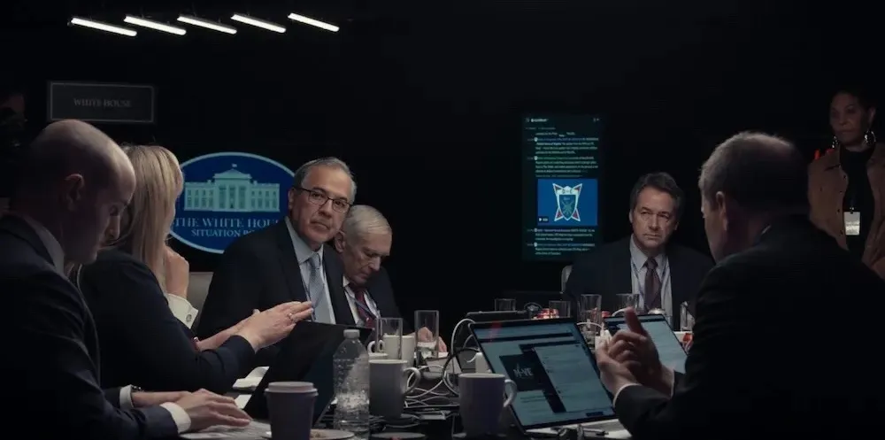 Men in suits sit around a table