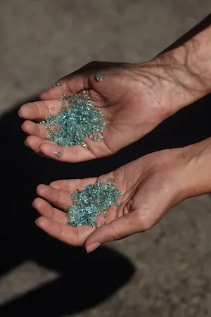 hands cupping small shards of glass