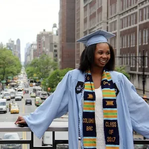 a graduate poses in cap and gown