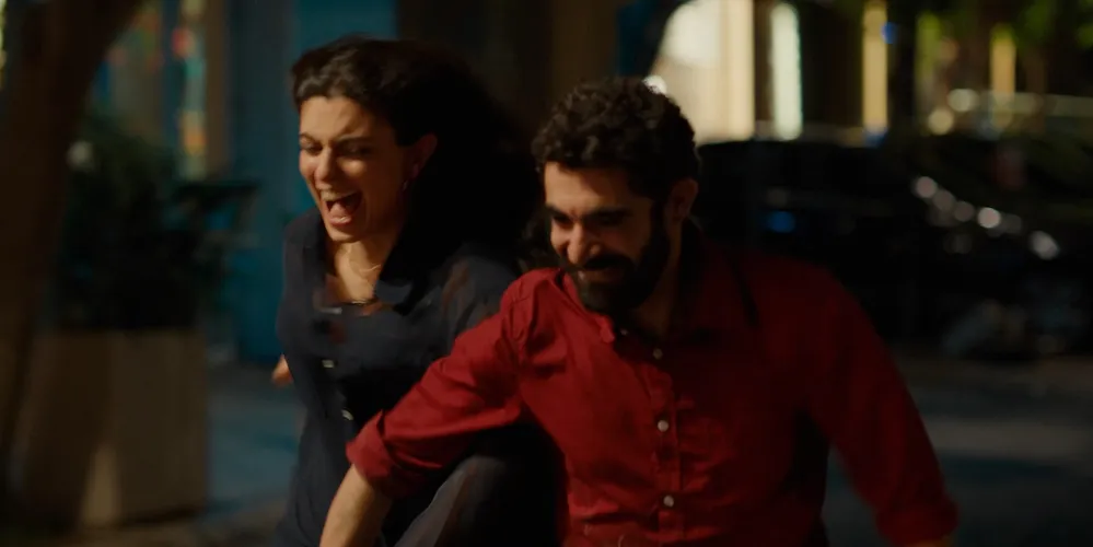 a man and woman run outside, arm-in-arm