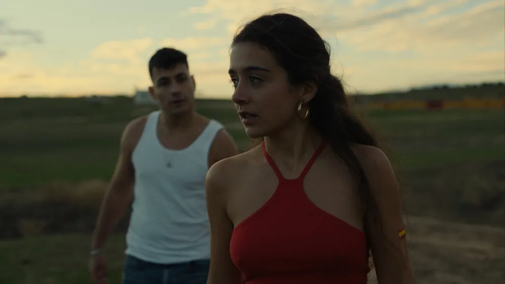 a man and woman stand next to each other outside near a field