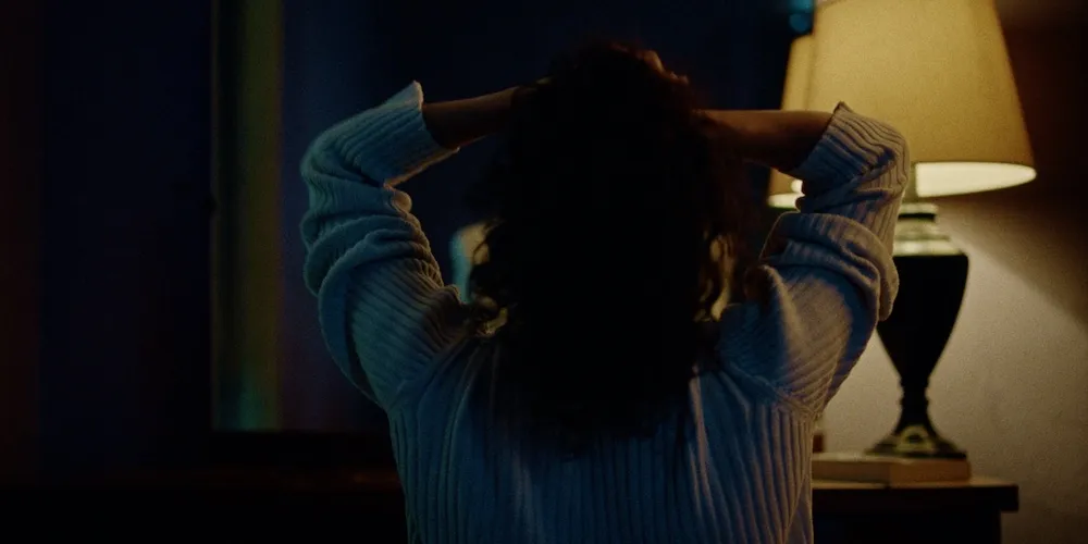 A woman in a dimly lit room. 