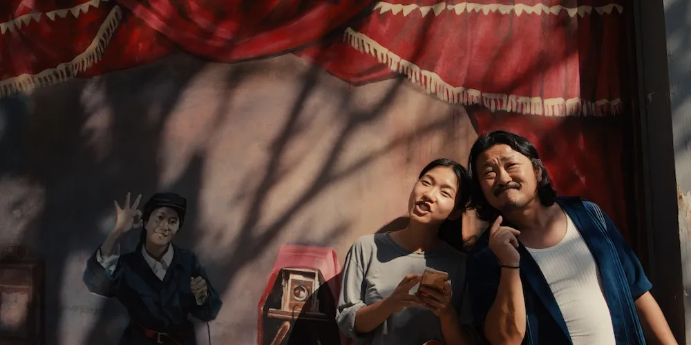 Two people lean against a wall