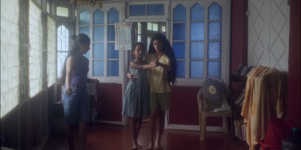 Three young girls dance in a sunny room