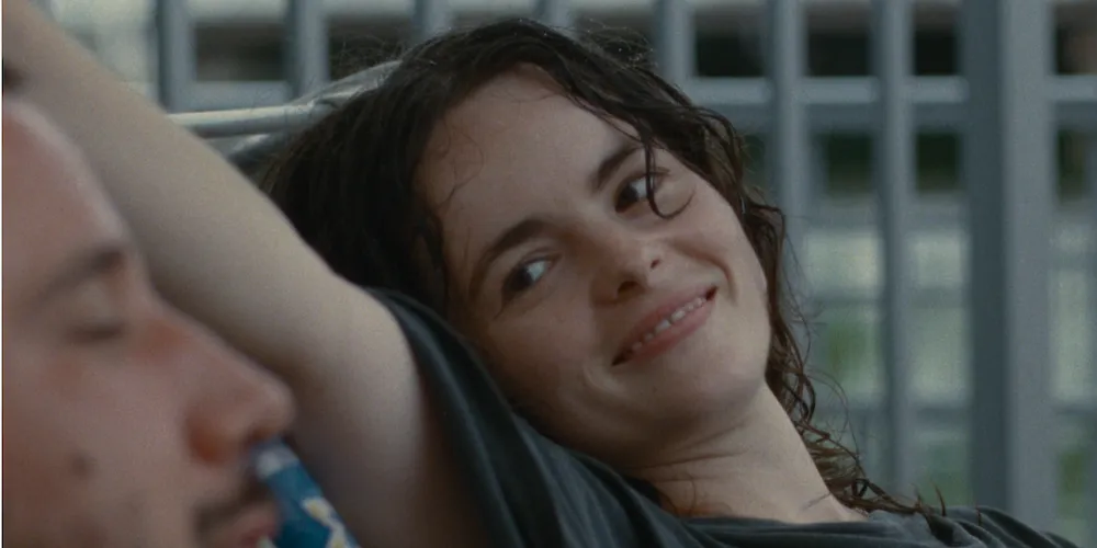 a young woman smiles at someone sitting next to her