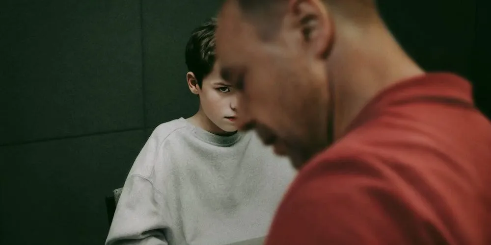 A boy looks up at a man. 