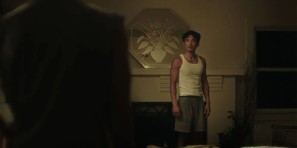 A man stands in a living room, looking upset