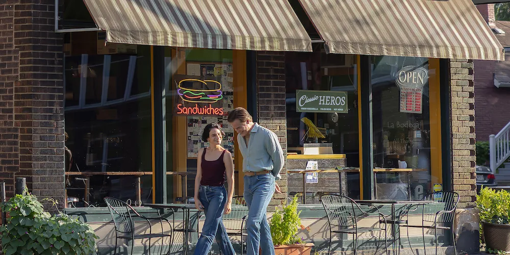 A man and woman walk down a main street