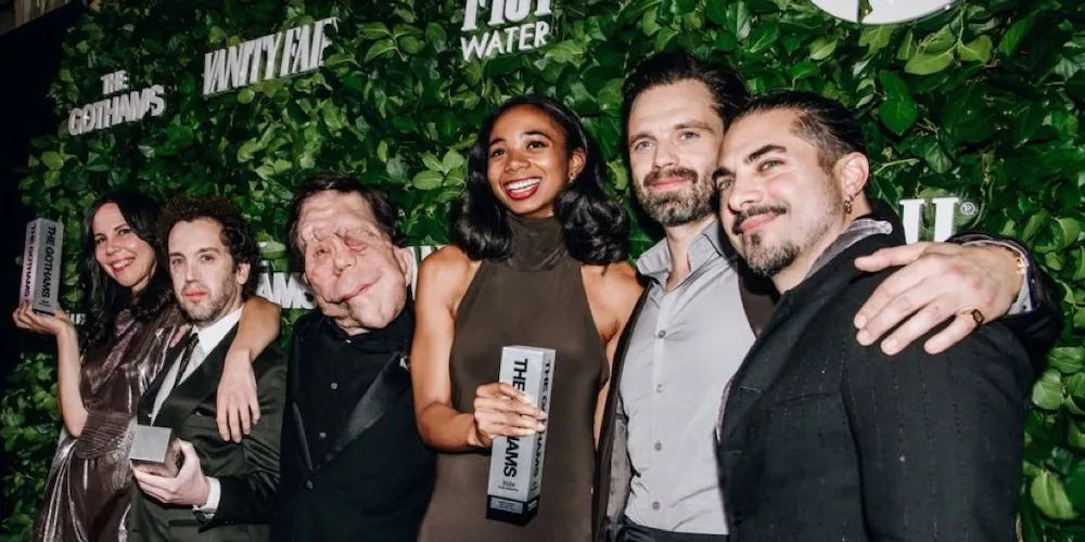 a group of people pose for a photo on the red carpet