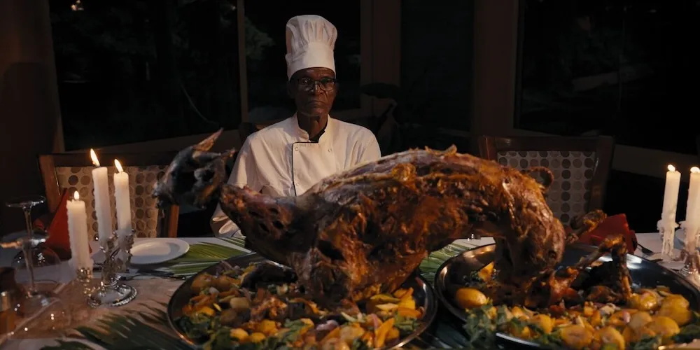 a chef sits at a table filled with gourmet food