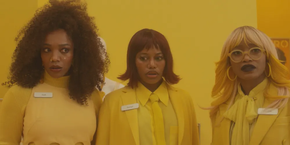 Three people wearing all yellow stand together in a yellow room