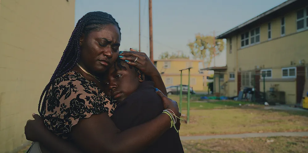 Two people embrace outside a house