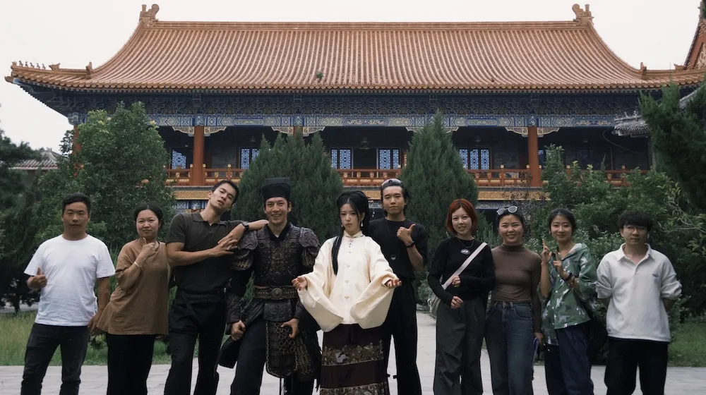 a group of people pose outside a building
