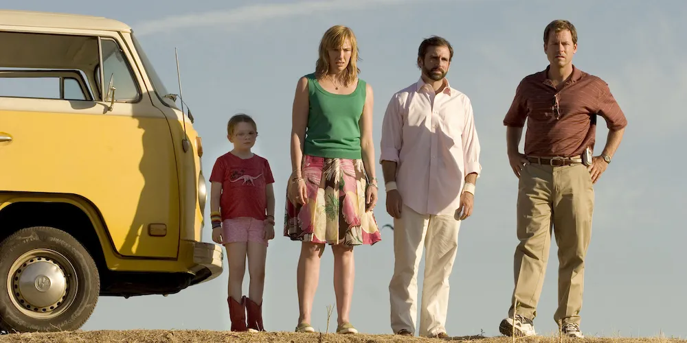 A group of people stand next to a yellow VW Bus. 