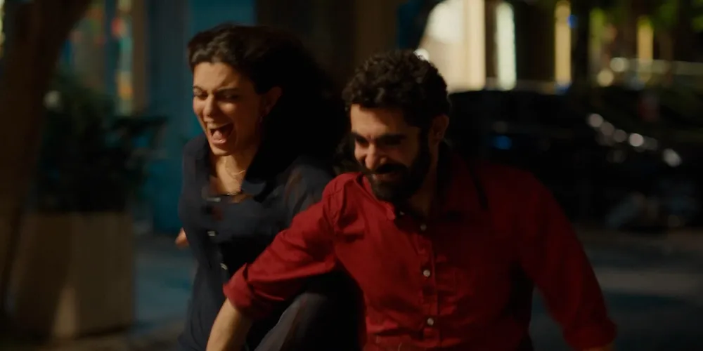 a man and woman run arm-in-arm outside