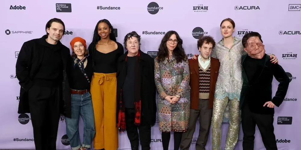 a group of people pose for a photo on the red carpet