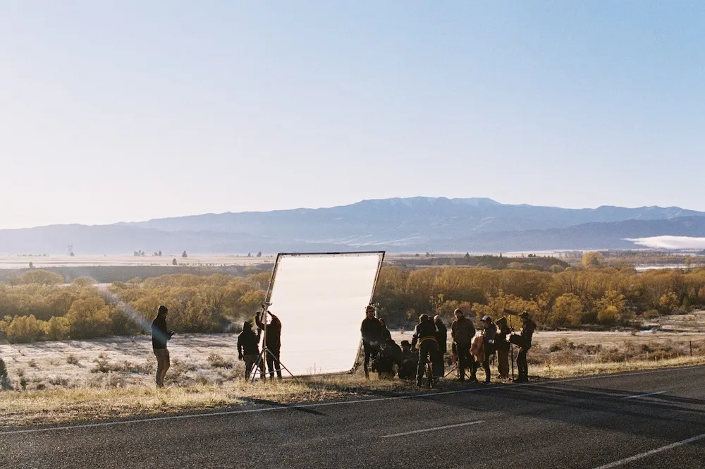 People stand in front of mountain range. 