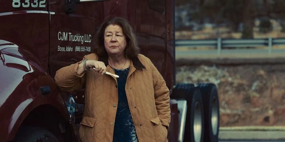 a woman leans against a semi-truck