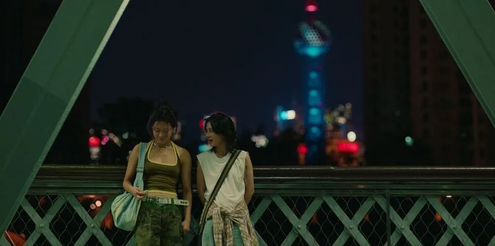 two people stand outside on a bridge