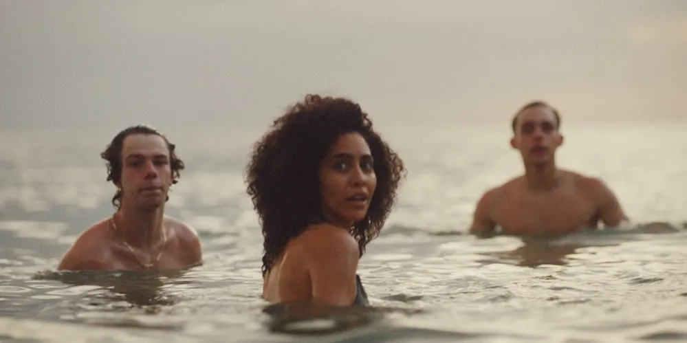 Two men and one woman in the ocean