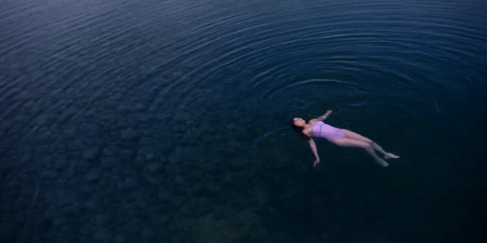 A woman floats in an expanse of water