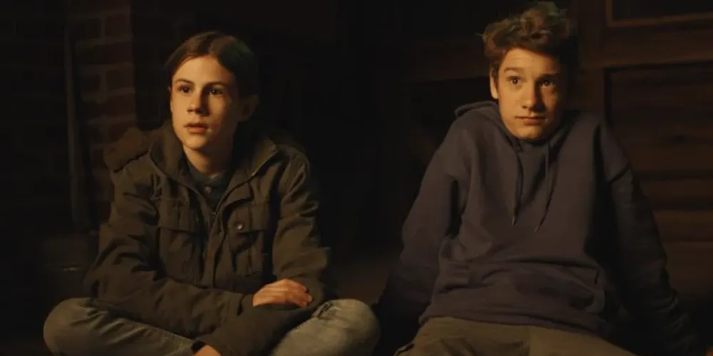 Two boys sit on the ground