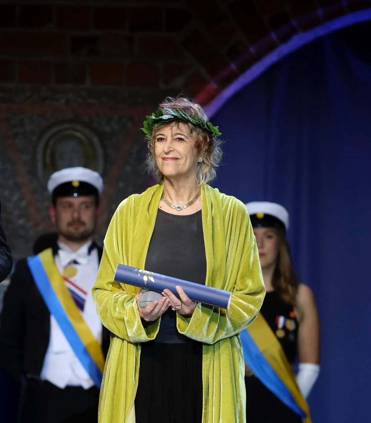 A woman stands on a stage receiving an award