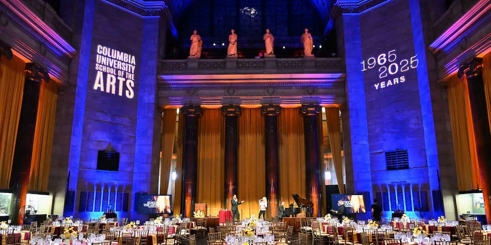 two performers sing on stage in a gala ballroom