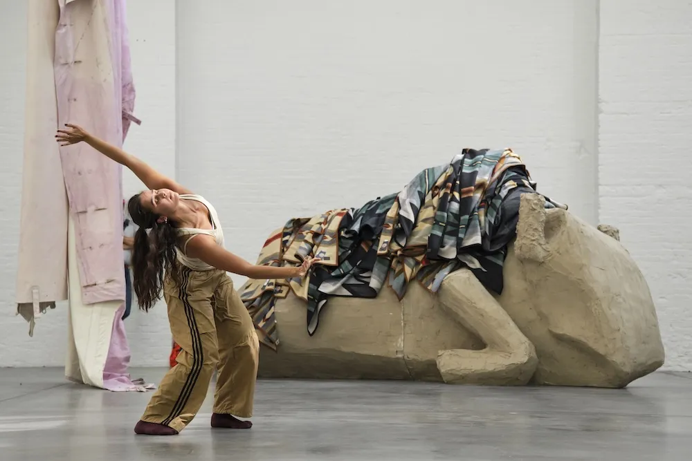 a performer dances in an art gallery