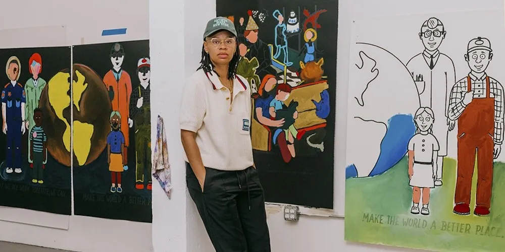 A painter poses with artwork. 