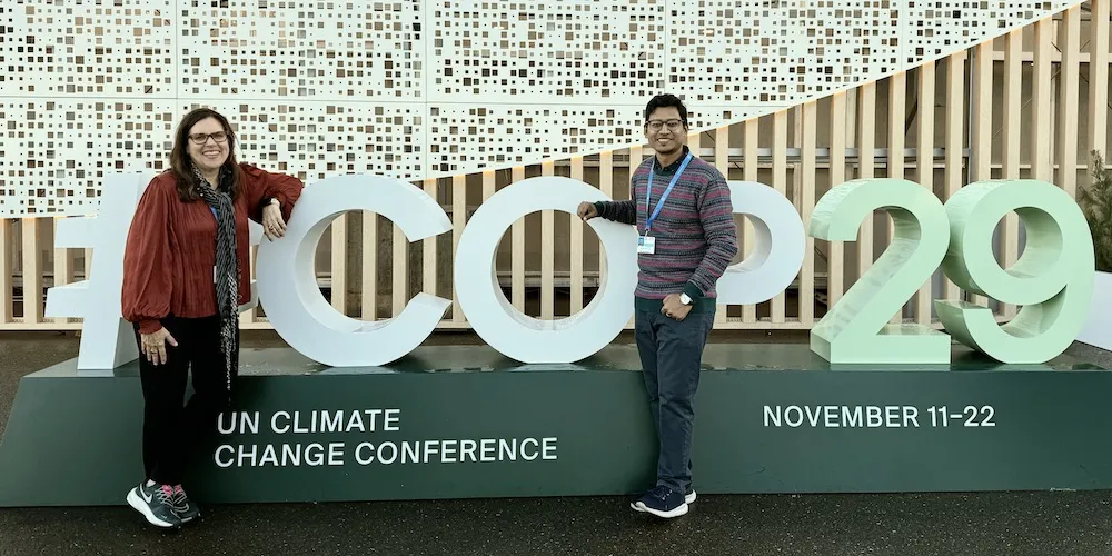People stand in front of COP29 sign. 