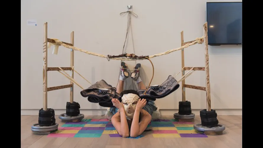 Student with a mask in front of an art exhibit.