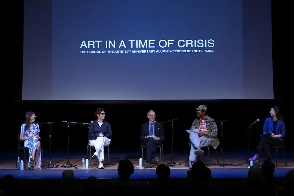 Panel of speakers on stage. 