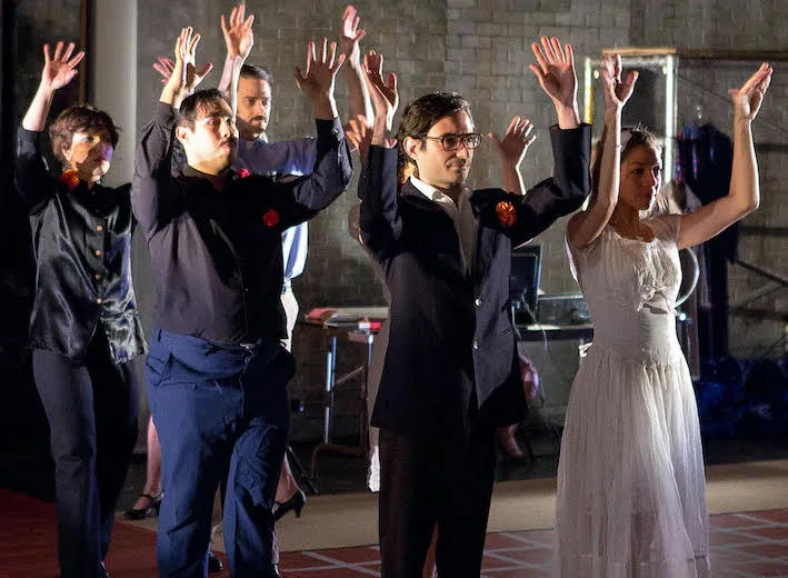 Group of performers standing with raised hands