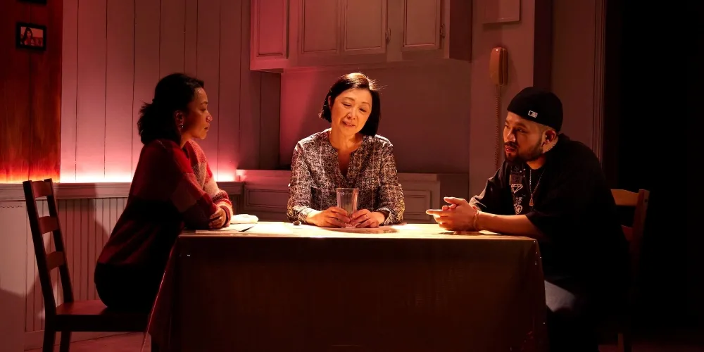Two women and a man at a dinner table.