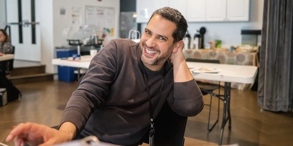 Man smiling in a brown sweater