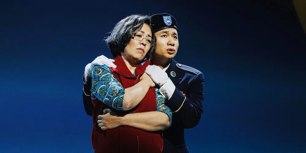 Two people stand on stage. 