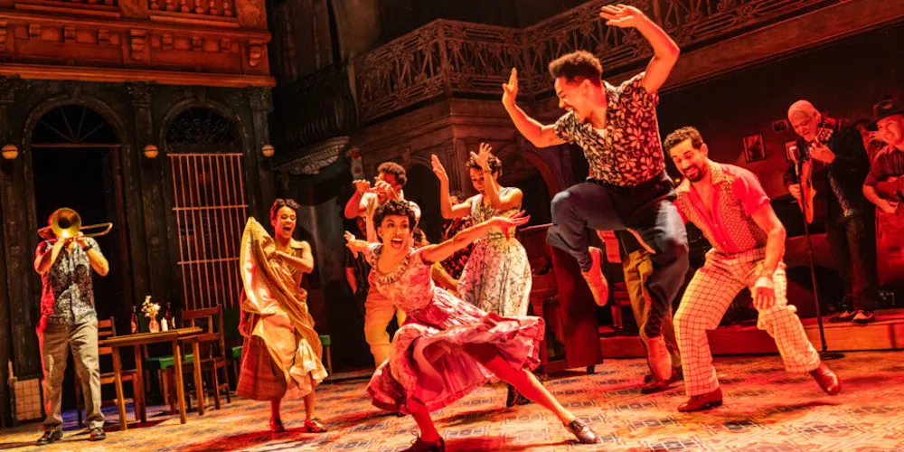 Actors dance on stage.