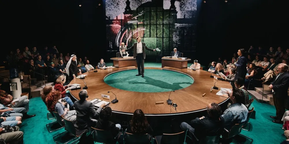 actors perform on a round stage in front of an audience