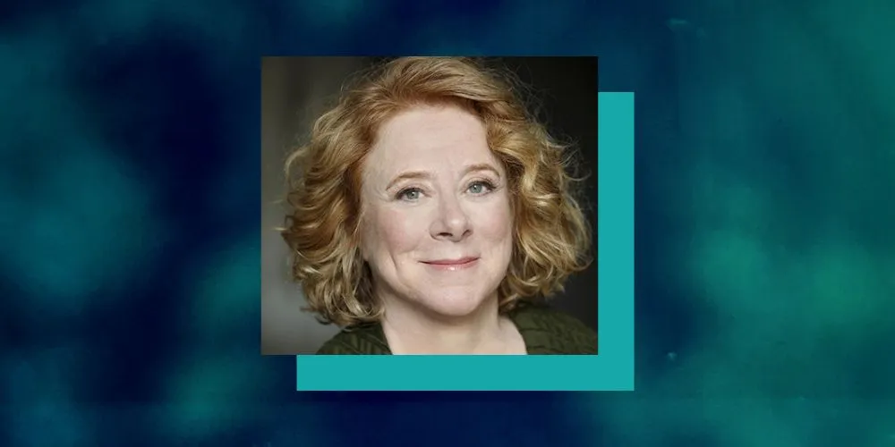Headshot of a woman with short red curly hair with a blue and turquoise border. 