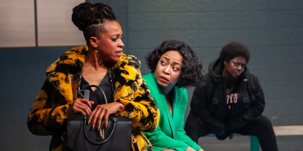 a woman in a green jacket looks over the shoulder of a woman with a purse